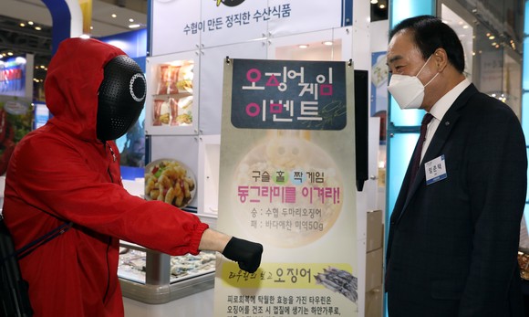 3일 부산 벡스코에서 열린 부산국제수산엑스포에서 임준택 수협중앙회장(오른쪽)이 홍보부스 방문객을 위해 마련된 '오징어게임' 수산물 증정 이벤트를 체험해보고 있다. ⓒ 수협중앙회