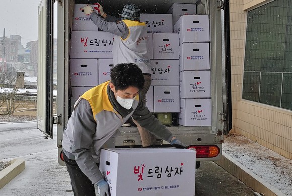 지난 27일 한국동서발전(주) 당진발전본부 봉사단 직원이 석문면사무소에서 '빛드림 선물상자'를 운반하고 있다. ⓒ 당진발전본부