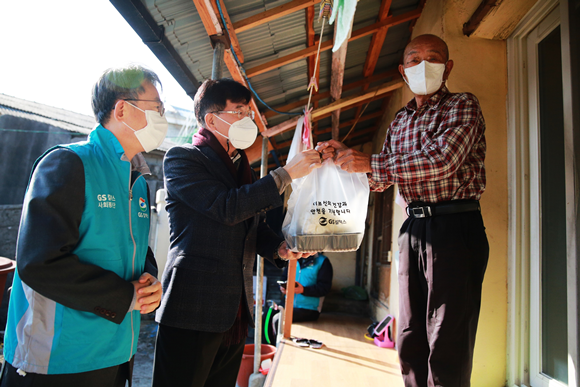 여수시 서정신 환경복지국장과 오문현 대외협력부문장(왼쪽)이홀몸 어르신 가정을 방문해 떡국과 밑반찬을 전달하고 있다 ⓒ GS칼텍스.