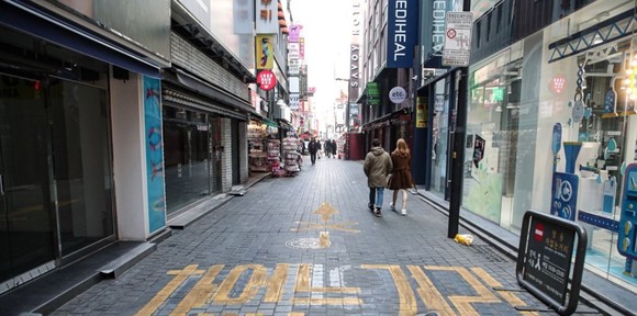 명동거리에 외출한 시민들이 폐업한 상가 앞을 지나고 있다. ⓒ 연합뉴스