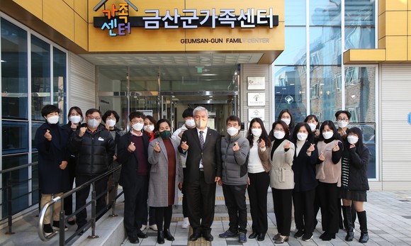문정우 금산군수와 금산군가족센터 직원들이 교체된 금산군가족센터 현판 앞에서 기념촬영을 하고 있다. ⓒ 금산군