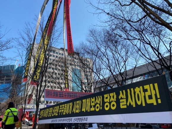 신라젠 주주들이 한국거래소 앞에서 현수막을 걸고 시위를 벌이고 있다. = 이정훈 기자