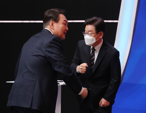 국민의힘 윤석열 대선 후보(왼쪽)와 더불어민주당 이재명 대선 후보가 지난달 21일 오후 서울 마포구 MBC 미디어센터 공개홀에서 열린 중앙선거방송토론위원회 주관 제20대 대통령선거 후보 초청 1차 토론회 시작에 앞서 인사하고 있다. ⓒ 연합뉴스
