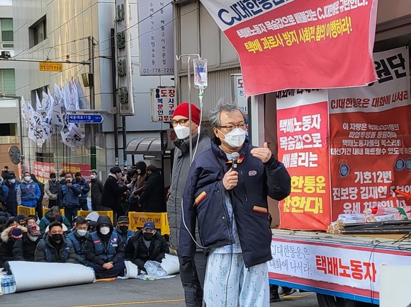아사단식 6일째 병원에 이송된 진경호 택배노조 위원장이 2일 서울 중구 CJ대한통운 본사 앞에 환자복을 입고 나타나 택배노조의 입장을 발표하고 있다. = 이수영 기자