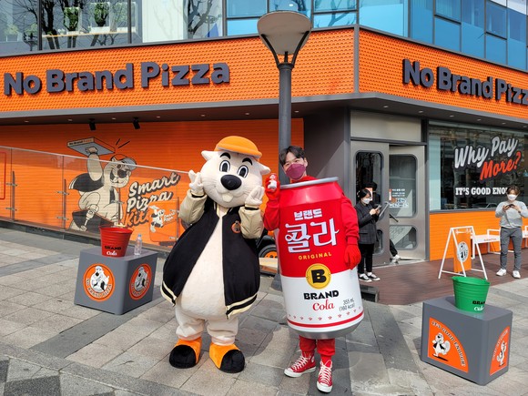 노브랜드 피자 대치점 오픈 첫날인 10일, 피버맨과 콜라맨이 매장 앞에서 포즈를 취하고 있다. =윤수현 기자