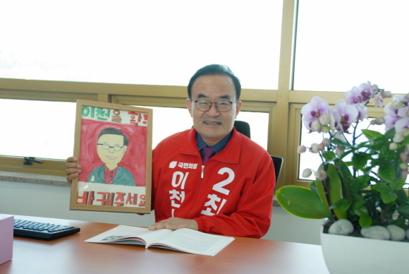 '이천을 확 바꾸자'라는 슬로건과 함께 선거전에 돌입한 최형근 이천시장 예비후보는 △신도시건설 △테크노밸리조성 △설봉산 국가정원 지정 등이 포함된 10대 공약을 내세웠다. 사진은 한 초등생이 그려준 그림을 들고 있는 최 예비후보. =전대현 기자