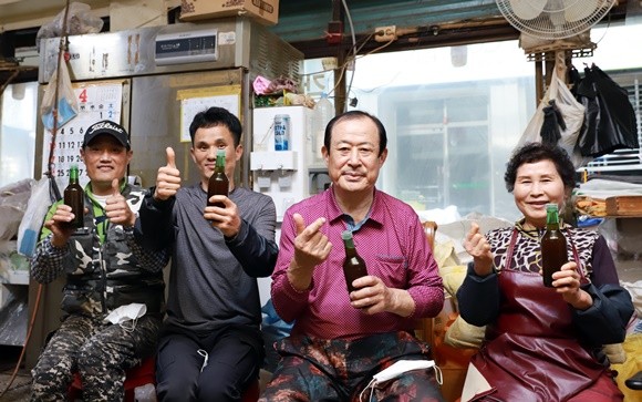이재관 여수방앗간 대표(오른쪽에서 두번째)가 아내와 아들하고 순수 국내산 참기름을 들고 기념촬영을 하고 있다. ⓒ 프라임경제