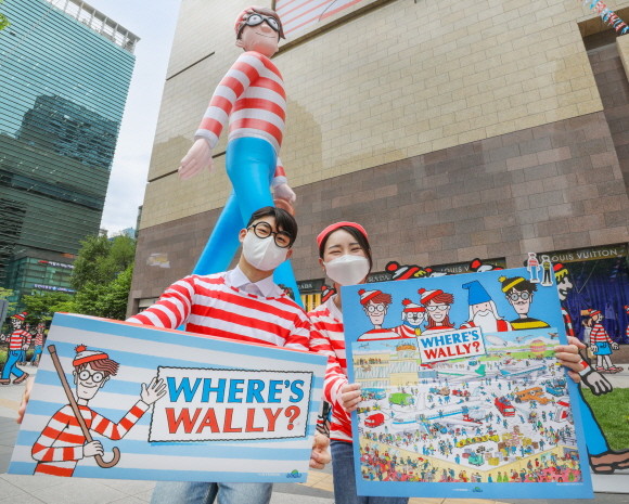 지난 1일 오전, 서울 강남구에 위치한 현대백화점 무역센터점 정문에 설치된 대형 벌룬 월리 앞에서 직원들이 다양한 월리 콜라보 굿즈 상품을 선보이고 있다. © 현대백화점