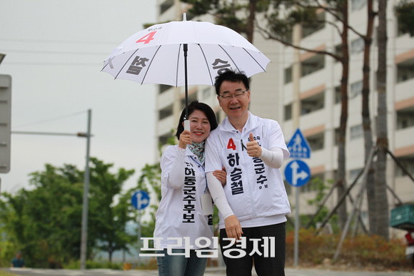 비내리는 하동군민 아침인사에서 차양진 배우자가 하승철 후보에게 다정하게 우산을 받혀주고 있다. ⓒ 프라임경제