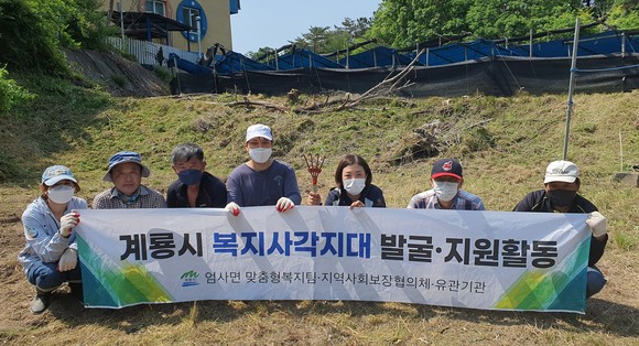 지난 25일 주거환경개선에 참여한 협의체 위원과 엄사면 직원이 기념촬영을 하고 있다. ⓒ 계룡시
