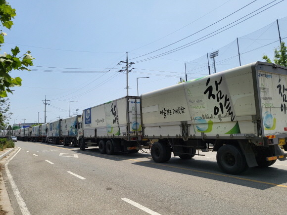 민주노총 화물연대가 파업 철회를 결정했지만 하이트진로 이천·청주 공장에서는 파업이 계속되면서 주류 공급에 차질을 빚고 있다. 사진은 이천공장 상하행도로에 길게 주차된 화물차량. ⓒ 하이트진로
