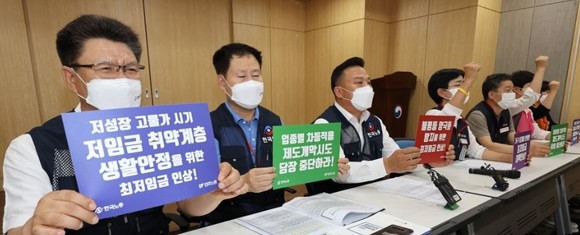 최저임금위원회 회의에 참석하는 근로자 위원들이 21일 오후 세종시 정부세종청사에서 열리는 제5차 전원회의에 앞서 2023년 적용 최저임금 노동계 요구안 발표 기자회견을 하며 구호를 외치고 있다.ⓒ 연합뉴스