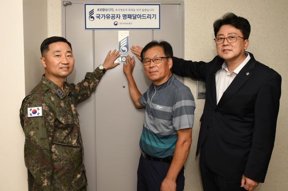 공군 제1전투비행단은 호국보훈의 달을 맞아 국가유공자 명패 달아드리기 행사를 실시했다. 류진산 공군 제1전투비행단장과 임종대 광주 지방 보훈청장이 화랑무공훈장을 수훈한 故 문창순 옹의 집에 명패를 전달한 후 기념촬영을 하고 있다. ⓒ중사 박성현