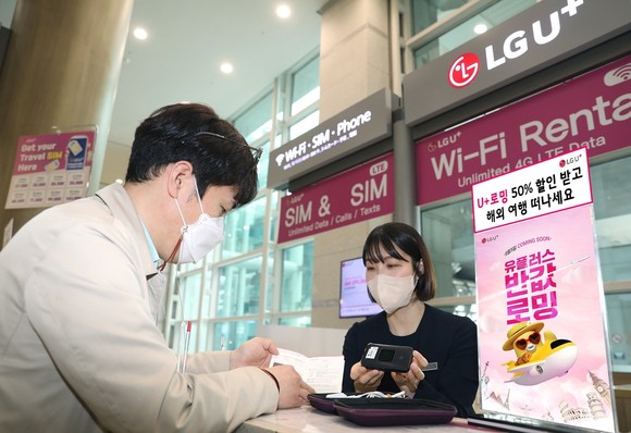 LG유플러스 임직원이 인천 공항에 위치한 LG유플러스 로밍센터에서 고객과 대화하는 모습. ⓒ LG유플러스
