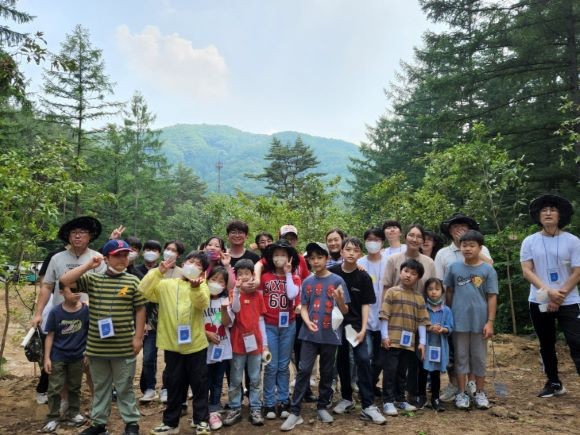 국립양평치유의 숲에서 진행된 교통약자를 위한 작은숲 조성 봉사활동을 마치고 두나무 임직원 및 가족들이 단체 사진을 촬영하고 있다. ⓒ 두나무