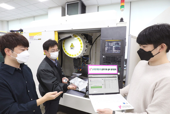 양사 직원들이 화낙의 소형 머시닝센터(MCT)를 이용한 공작기계 앞에서 통신 중계기 부품 가공 과정을 U+스마트팩토리 관제시스템을 통해 모니터링 하는 모습. ⓒ LG유플러스