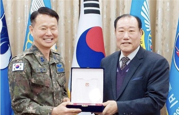 한국우리밀농협 천익출 조합장이 코로나로 어려워진 농업 농촌의 어려움을 타개하는데 적극 앞장서왔던 제1전투비행단 이태규 단장에게 감사의 마음을 담은 패를 전달하고 있다. Ⓒ 한국우리밀농협