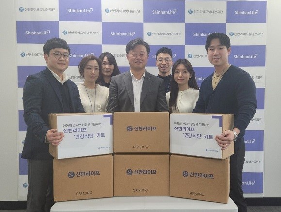 김순기 신한라이프빛나는재단 사무국장(가운데)과 신한라이프 임직원들이 결식 우려 아동에게 전달할 건강식단 키트와 함께 서 있다. ⓒ 신한라이프