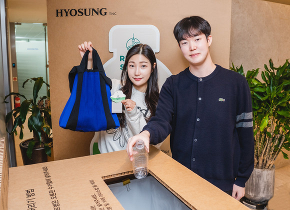 효성티앤씨 직원들이 페트병 수거함 앞에서 리젠 적용 가방과 재활용할 페트병을 들고 있다. ⓒ 효성티앤씨