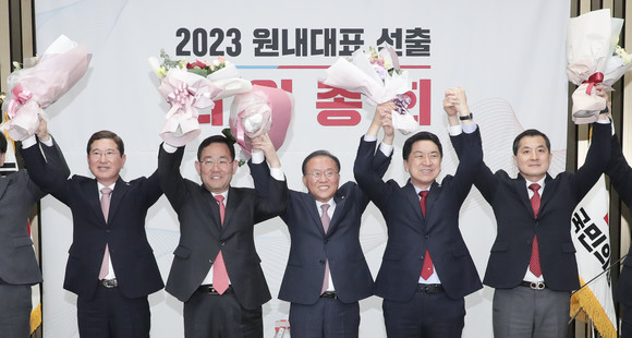 윤재옥 국민의힘 신임 원내대표(가운데)가 7일 오전 국회에서 열린 국민의힘 원내대표 선출을 위한 의원총회에서 당선 확정 후 김기현 대표, 주호영 전 원내대표 등 지도부와 꽃다발을 들고 인사하고 있다. ⓒ 연합뉴스