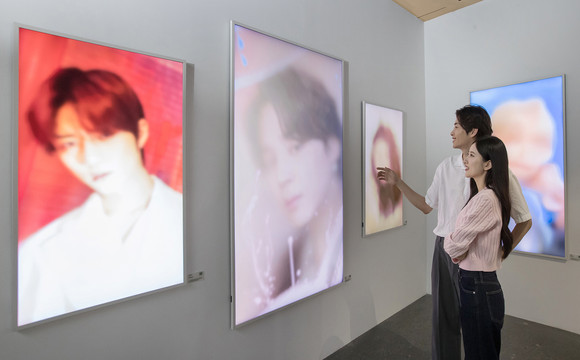 삼성전자 모델들이 지난 9일부터 서울 강남구 삼성동에서 진행 중인 하이브 레이블즈 소속 아티스트 초상 사진 전시회 'The Daydream Believers : 꿈, 마침내'를 관람하고 있는 모습. ⓒ 삼성전자