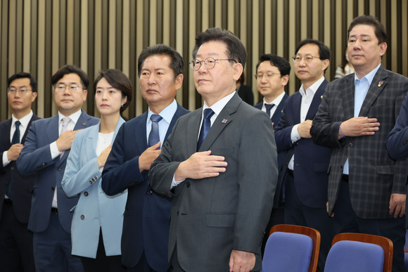 이재명 더불어민주당 대표와 의원들이 21일 국회에서 열린 의원총회에서 국기에 경례하고 있다. ⓒ 연합뉴스
