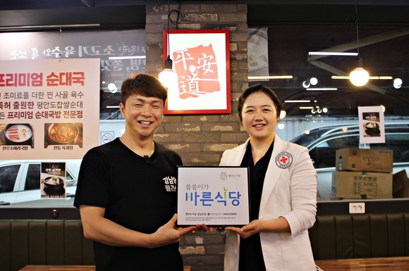 유튜브 강남역클라쓰와 평안도식당을 운영중인 강혁주 대표(왼쪽)를 방문해 씀씀이가 바른기업 명패를 전달한 김유진 적십자사 서울지사 과장(오른쪽)이 기념사진을 촬영하고 있다. ⓒ 대한적집자사 서울특별시지사