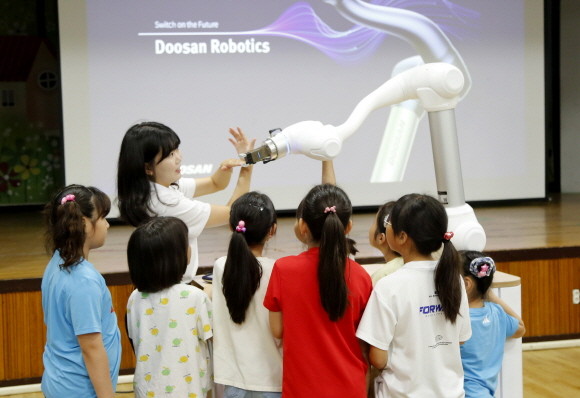 두산로보틱스 임직원이 아이들에게 협동로봇의 개념과 기본적인 작동 과정 등을 교육하고 있다. ⓒ 두산로보틱스