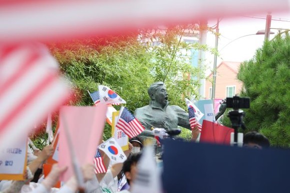 28일 오후 광주 남구 정율성 흉상 앞에서 자유통일당 관계자들과 극우 보수단체들이 태극기와 성조기를 들고 기념사업에 반대하는 집회를 열고 있다. ⓒ 프라임경제