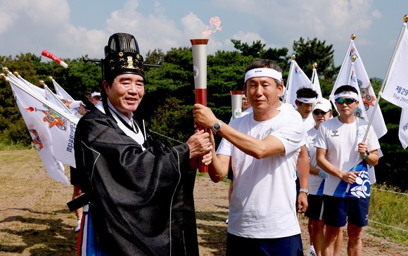 김동일 보령시장은 6일 남포향교가 주관 옥마산에서 열린 성화 채화 행사에 참여해 시민들의 환호와 응원 속에서 첫번째 봉송 주자에게 전달하고 있다. ⓒ 보령시