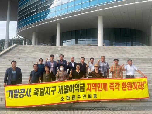 최무경 의원과 주민들이 현수막을 들고 여수 죽림1지구 도시개발사업 개발이익금을 환원하라고 주장했다. ⓒ 의원사무실