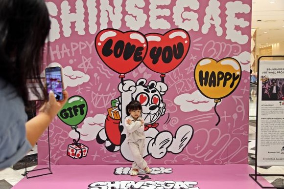 광주신세계 1층에 조성된 지역작가 협업 아트월(ART WALL) 프로젝트 포토존에서 아이가 포즈를 취하고 있다. ⓒ 광주신세계
