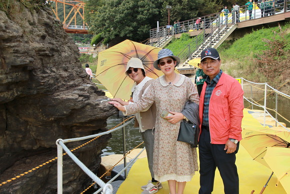 관람객들이 솥바위에서 소원을 빌고 환하게 웃고 있다. ⓒ 프라임경제