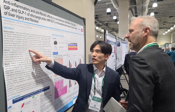 R&D센터 김정국 연구원(왼쪽)이 11일(현지시각)미국 보스턴에서 열린 미국간학회국제학술대회에서 MASH 치료 혁신신약으로 개발중인 에포시페그트루타이드의 간 섬유화 개선 효능에 대해 설명하고 있다. © 한미약품