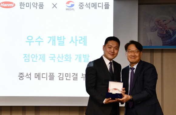 한미약품 구매팀 김규식 이사(오른쪽)가 '협력업체 우수 개발 사례'를 발표한 중석메디플 김민결 부장(왼쪽)에게 공로패를 수여하며 기념촬영을 하고 있다. © 한미약품