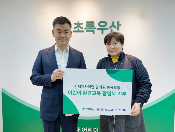 신세계사이먼은 7일 오전 서울시 중구 초록우산 어린이재단 본부에서 '어린이 환경교육 팝업북 기부' 전달식을 진행했다. (왼쪽부터) 이현수 신세계사이먼 CSR팀 팀장, 최운정 초록우산어린이재단 서울2지역본부 본부장. © 신세계사이먼