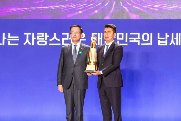 4일 오전 10시 서울 동대문디자인플라자(DDP)에서 열린 제58회 납세자의 날 기념식에서 우아한형제들이 고액 납세의 탑 수상 법인으로 선정됐다. 이국환 우아한형제들 대표(오른쪽)가 최상목 부총리 겸 기획재정부 장관으로부터 고액 납세의 탑 트로피를 받고 기념 사진을 촬영하고 있다. © 우아한형제들