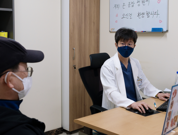 김건국 전 가천의대 길병원 간담췌외과 교수가 외래 진료 온 방문자와 대화하고 있다.ⓒ프라임경제