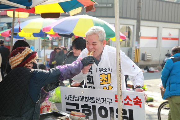노포 음식 아주머니가 무소속 최상화 후보에게 호떡을 먹여주고 있다. ⓒ 프라임경제