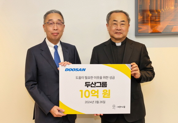 박지원 두산그룹 부회장(왼쪽)과 손희송 재단법인 바보의 나눔 이사장이 지난 26일 명동성당에서 열린 성금 전달식에서 기념촬영을 하고 있다. ⓒ 두산그룹