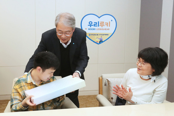 임종룡 우리금융 회장이 시각·청각 수술비 지원에 선정된 장애아동에게 선물을 전달하고 있다. ⓒ 우리금융그룹