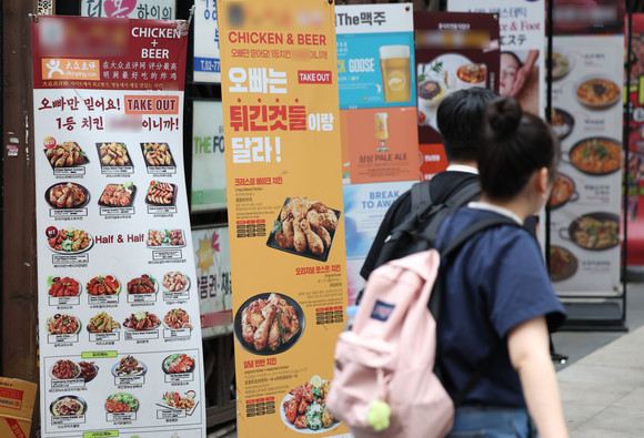 서울 중구 명동 거리 한 음식점에 치킨, 피자 등 메뉴판이 붙어있다. ⓒ 연합뉴스