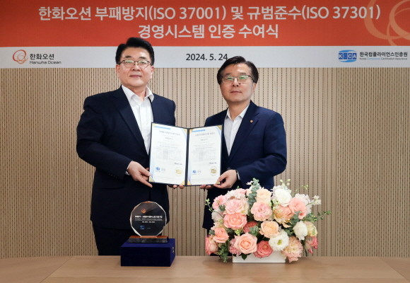 지난 24일 권혁웅 한화오션 대표이사(오른쪽)와 이원기 한국컴플라이언스인증원 원장이 참석한 가운데 장교동에 위치한 한화빌딩에서 'ISO 37001, 37301' 인증서 수여 후 기념촬영을 하고 있다. ⓒ 한화오션