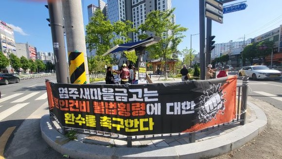 염주새마을금고 회원들이 서류를 조작해 부당하게 수급된 인건비와 업적 달성금을 환수해 회원들에게 배당금으로 돌려주자는 서명운동을 전개하고 있다. ⓒ 염주새마을금고