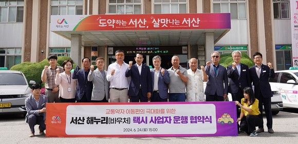 24일 이완섭 서산시장과 개인택시 사업자 5명이 시청 본관 앞에서 교통약자 해누리(바우처) 택시 업무협약식을 개최 후 기념촬영을 하고 있다. ⓒ 서산시