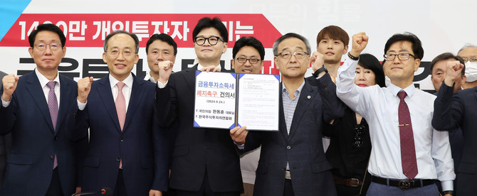 국민의힘 한동훈 대표와 추경호 원내대표 등 참석자들이 24일 오전 국회에서 열린 '1400만 개인투자자 살리는 금융투자소득세 폐지' 촉구 건의서 전달식에서 기념촬영을 하고 있다. ⓒ 연합뉴스