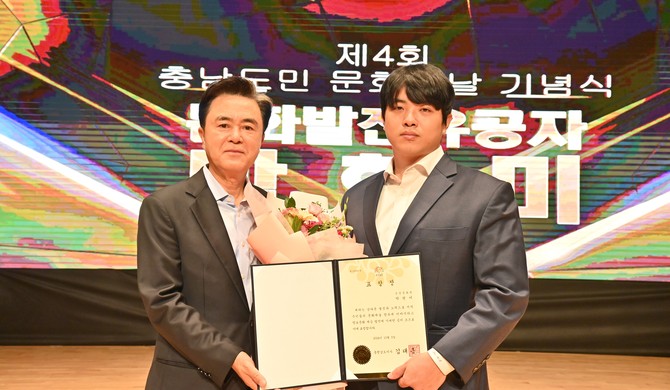 김태흠 충남지사가 지난 5일 도청 문예회관에서 열린 ‘2024 충남도민 문화의 날 기념식 및 생활문화축제’에 참석해 온양문화원 문현미 씨에게 표창을 전달 후 기념촬영을 하고 있다. ⓒ 충남도
