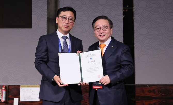 진성곤 대웅바이오 대표(왼쪽)가 지난 18일 '대한신경외과학회 추계학술대회'에서 명예회원증을 받고 권정택 대한신경외과학회 이사장과 기념촬영을 하고 있다. © 대웅바이오