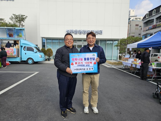 명성육가공 김성후 대표가 배해석 성주읍장에게 후원 물품을 전달하고 있다. = 김강석 기자