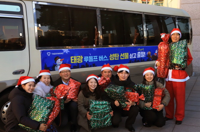 지난 18일 오전 광화문 흥국생명빌딩 앞 해머링맨 문화광장에서 태광산업·흥국생명·흥국화재·티알엔 임직원들이 산타 복장을 하고 '태광 루돌프 버스' 출정식 기념 촬영을 하고 있다. ⓒ 태광그룹